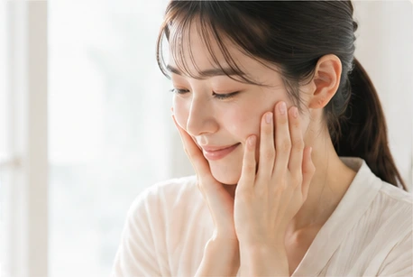 両手で素肌に触れる女性